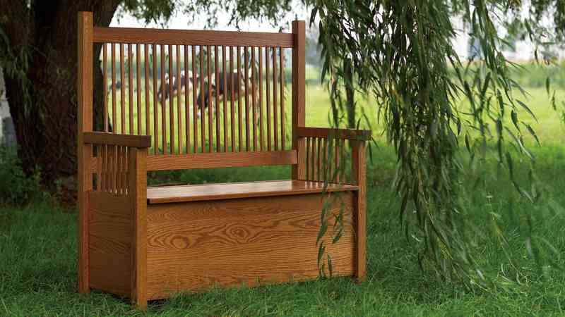 Deacon's bench set in a meadow with trees.